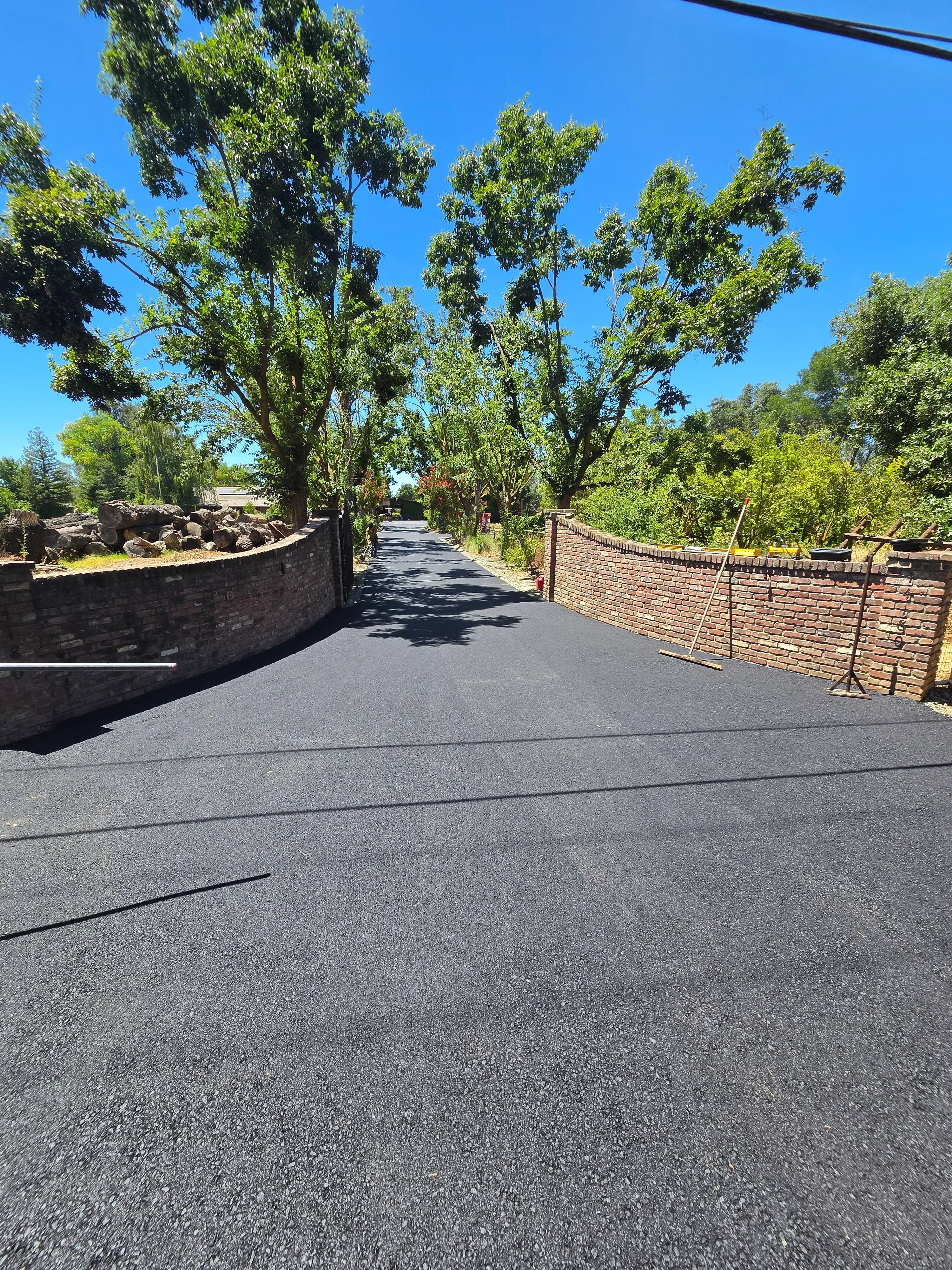 Newly paved asphalt driveway with clean edges and smooth dark surface finish